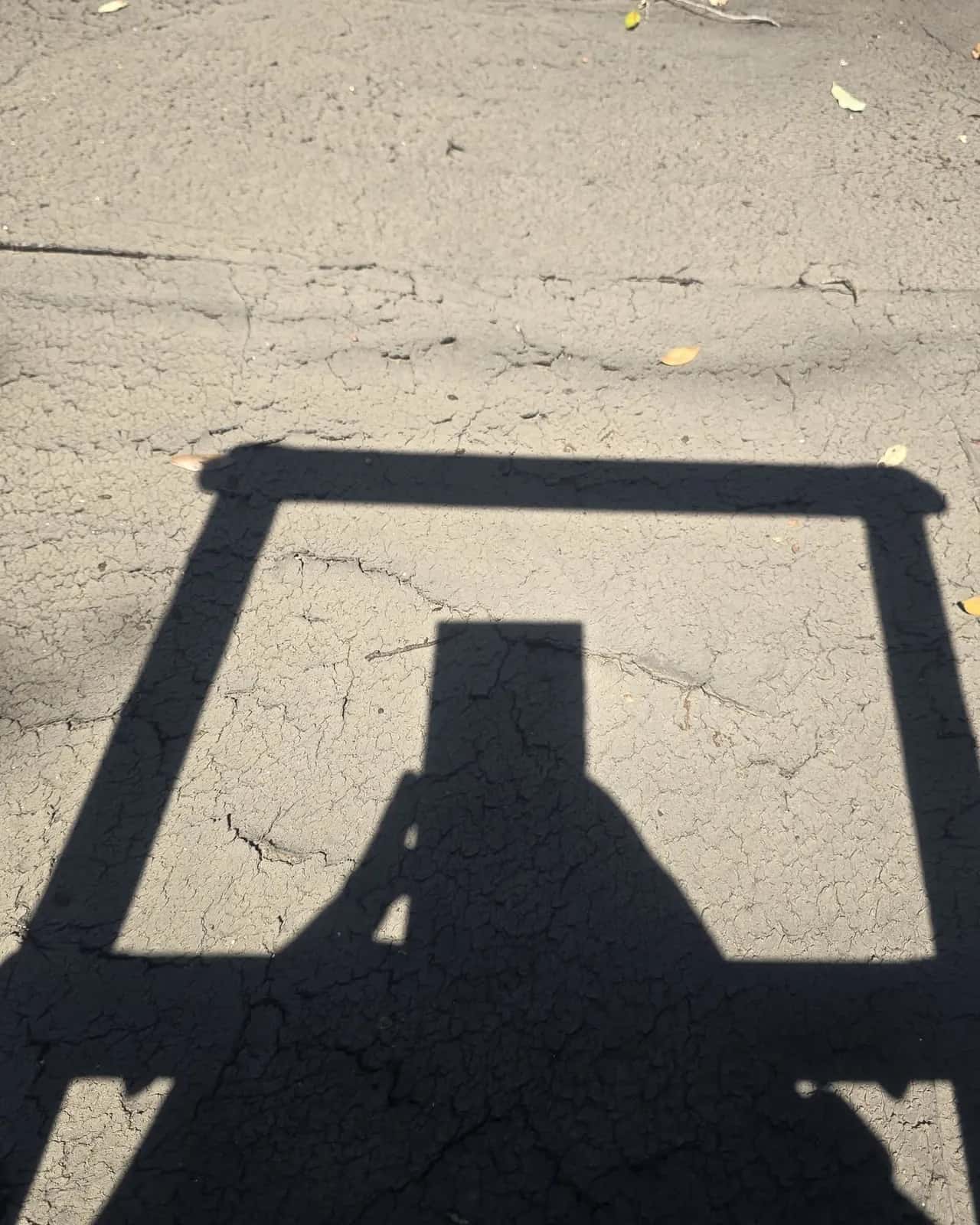 Aged low-slope roof surface with alligator cracking and shadows before replacement