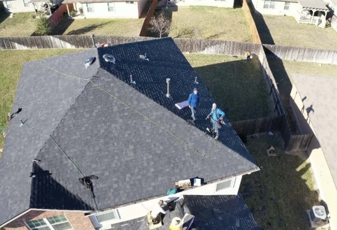 Overhead view of a Texas-RRR crew laying dark shingles on a San Antonio roof
